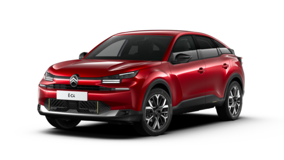 Ein rotes Auto mit einem modernen, sportlichen Design. Es hat schwarze Fensterrahmen und große Räder. Das Auto steht schräg nach links, mit einem markanten Frontgrill und schmalen Scheinwerfern.